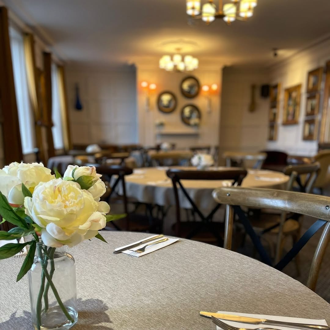 The Delaval Arms function room set for dining with flowers and warm pendant lights
